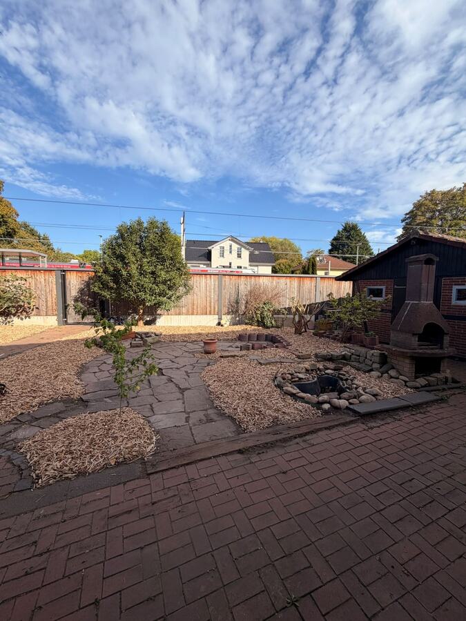 Fertig sanierter Garten mit Hackschnitzel-Beeten und Natursteinweg nach der Gartensanierung