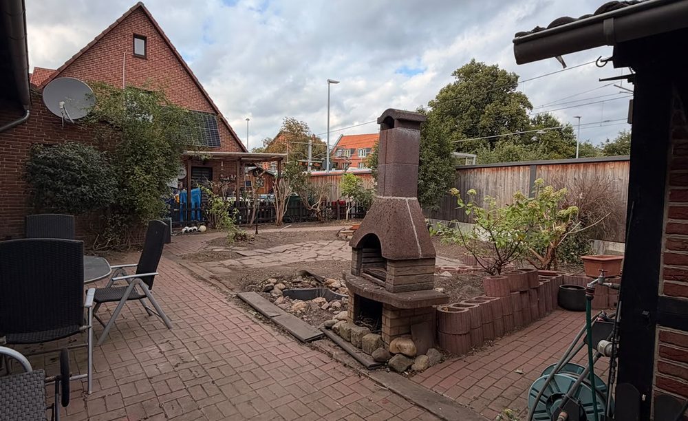 Aufgeräumter Hof mit freien Wegen und Beeten nach einem Herbsteinsatz