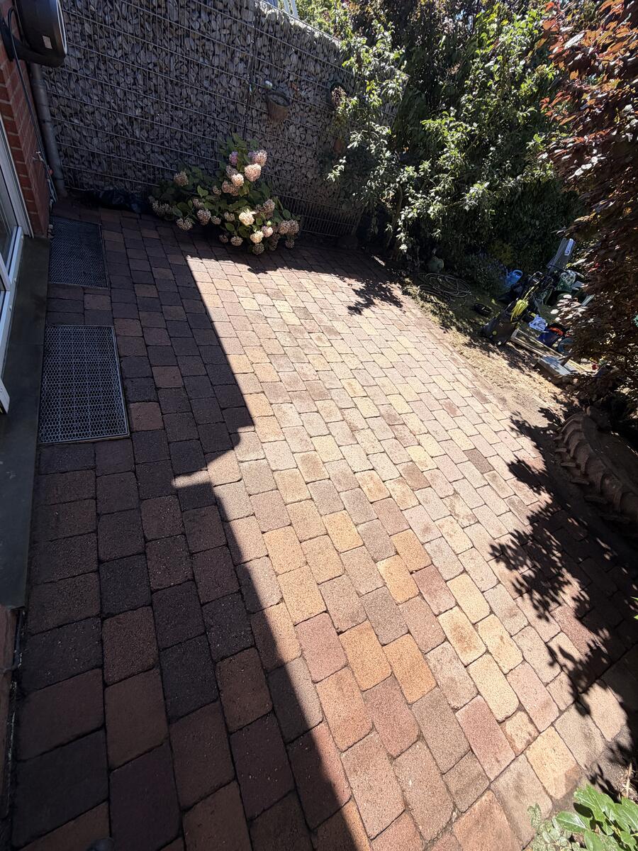 Terrassenreinigung nachher Hannover – gereinigtes Betonpflaster im Fischgrätverband in Terrakotta-Optik